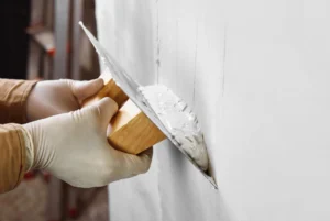 Enduit de lissage appliqué sur un mur avant finition